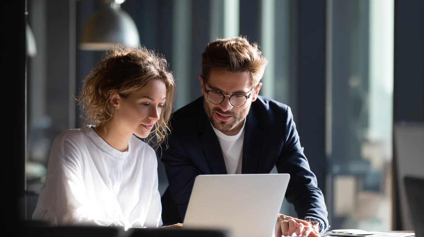 Two consultants reviewing work together on a laptop